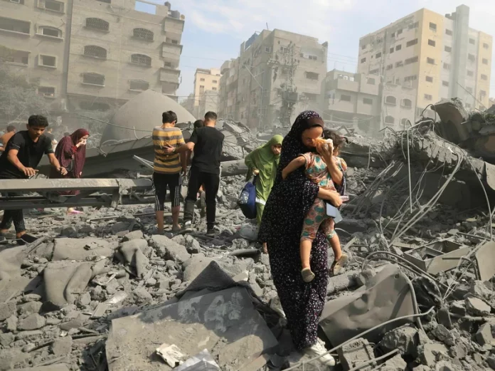 Palestinians evacuate the area following an Israeli airstrike on the Sousi mosque in Gaza City on October 9, 2023. Images of suffering, violence and death in Gaza and Israel have flooded the news since Oct. 7. MAHMUD HAMS/AFP via Getty Images"
